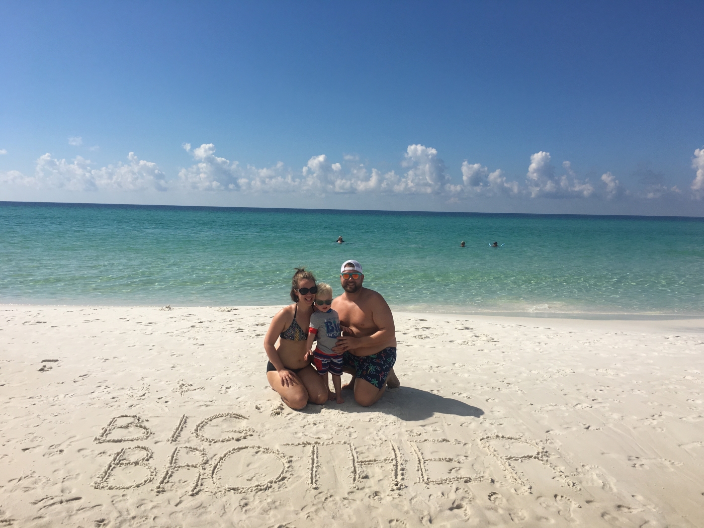 Family on the beach with Big Brother written in the sand