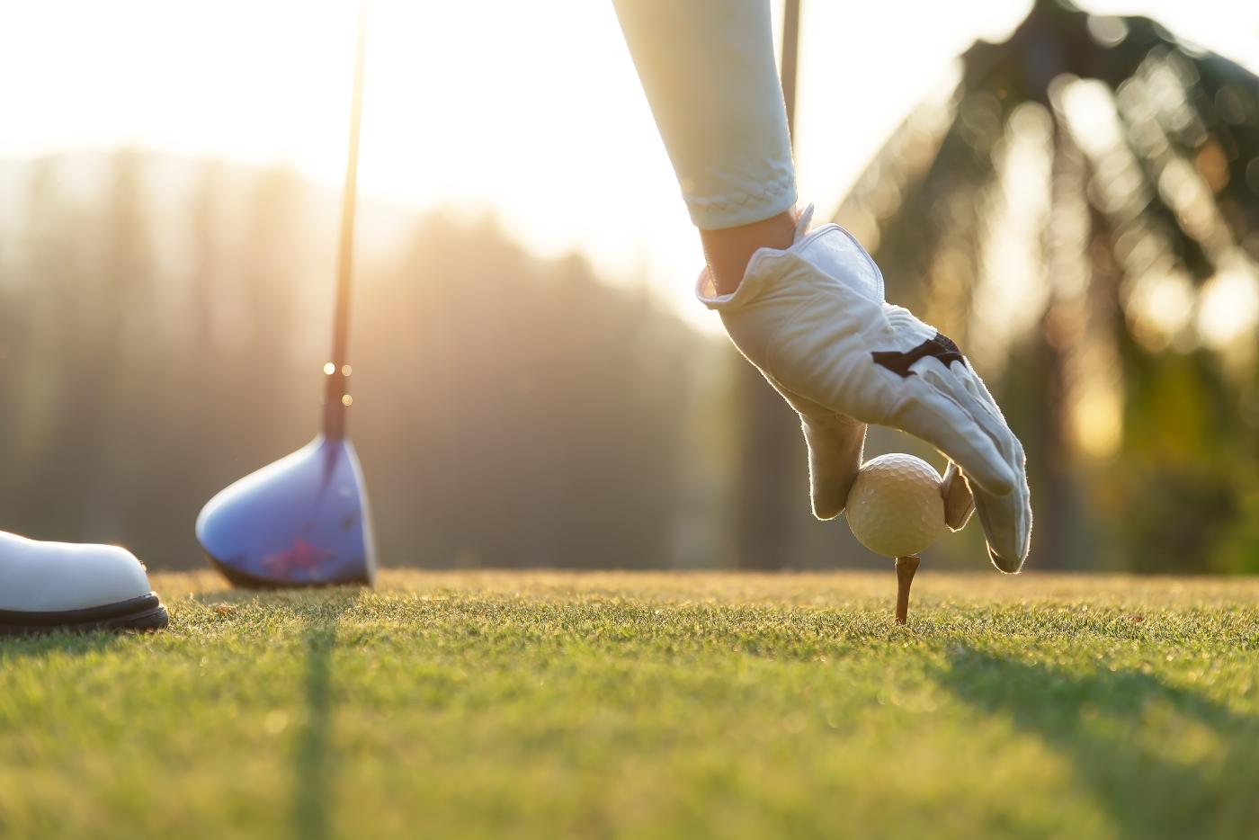 player placing a golf ball on a tee